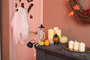 Cadılar Bayramı balkabaklı iskelet ve şömine rafında mumlar