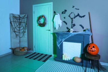 Cadılar Bayramı için salon kapısı ve şömine rafıyla süslenmiş.