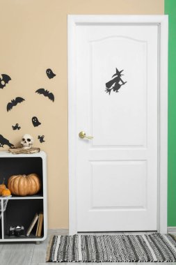 Cadılar Bayramı için salon kapısı ve raf ünitesi ile dekore edilmiş.