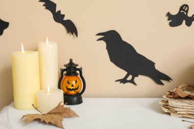 Düşmüş yapraklı mumlar ve koridordaki raflarda Cadılar Bayramı süsü