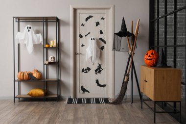 Cadılar Bayramı için salon kapısı ve raf ünitesi ile dekore edilmiş.