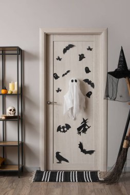 Cadılar Bayramı için salon kapısı ve raf ünitesi ile dekore edilmiş.