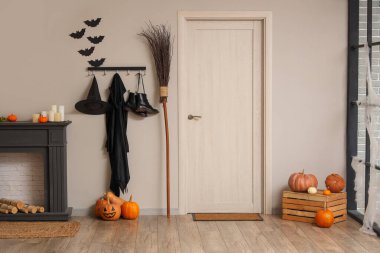 Cadılar Bayramı için şömine rafı ve kapıyla dekore edilmiş oturma odasının içi.