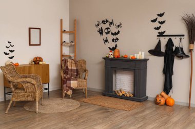 Cadılar Bayramı için dekore edilmiş oturma odasının içi şömine rafı ve koltuklarla dolu.