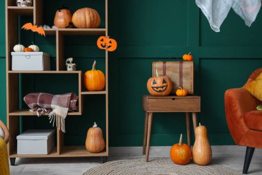 Oturma odasının içi Cadılar Bayramı için masa ve raf ünitesiyle dekore edilmiş.