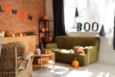 Cadılar Bayramı için kanepe ve balkabaklarıyla süslenmiş oturma odasının bulanık görüntüsü.