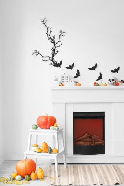 Cadılar Bayramı için dekore edilmiş oturma odasının içi şömine, balkabağı ve kağıt yarasalarla süslenmiş.