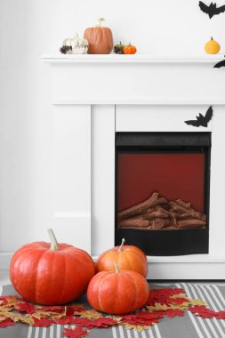 Sonbahar yapraklı Cadılar Bayramı balkabakları oturma odasında şöminenin yanında