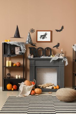 Cadılar Bayramı için dekore edilmiş oturma odasının içinde raf ünitesi ve şömine rafı var.