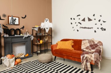 Cadılar Bayramı için kanepe ve şömine rafıyla dekore edilmiş oturma odasının içi.