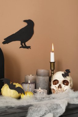 Kafatası yanan mumlar ve şömine rafında Cadılar Bayramı balkabakları, yakın plan.