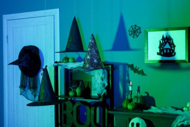 Cadılar Bayramı için dekore edilmiş karanlık oturma odasının içinde raf ünitesi var.