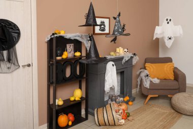 Oturma odasının içi Cadılar Bayramı için koltuk ve şömine rafı ile dekore edilmiş.