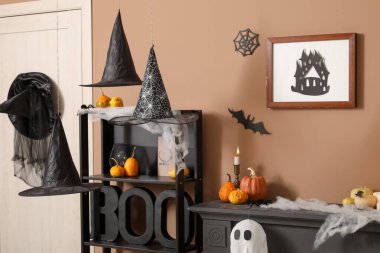 Cadılar Bayramı için dekore edilmiş oturma odasının içinde raf ünitesi ve şömine rafı var.