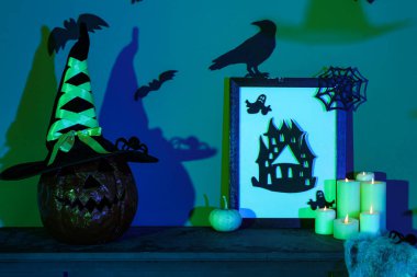 Cadılar Bayramı balkabağı dekorlu ve şömine rafında yanan mumlar karanlık odada