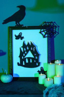 Cadılar Bayramı dekoru ve karanlık odada şömine rafında yanan mumlar.