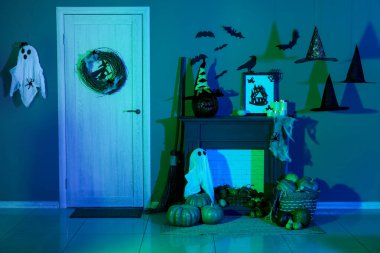 Cadılar Bayramı için kapı ve şömine raflarıyla dekore edilmiş karanlık oturma odasının içi.