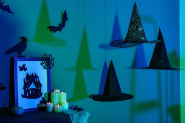 Cadılar Bayramı için dekore edilmiş karanlık odada asılı cadı şapkaları.