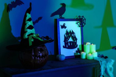 Cadılar Bayramı balkabağı dekorlu ve şömine rafında yanan mumlar karanlık odada