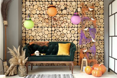 Cadılar Bayramı için yeşil kanepe ve merdivenle dekore edilmiş oturma odasının içi.