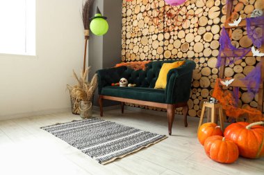 Cadılar Bayramı için yeşil kanepe ve merdivenle dekore edilmiş oturma odasının içi.