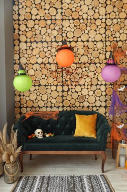 Cadılar Bayramı için yeşil kanepe ve merdivenle dekore edilmiş oturma odasının içi.