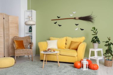 Cadılar Bayramı için sarı kanepe ve koltuk ile dekore edilmiş oturma odasının içi.