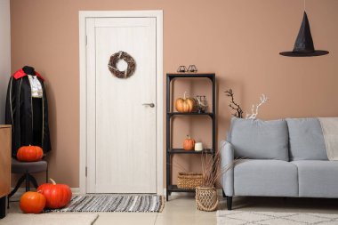 Cadılar Bayramı için dekore edilmiş oturma odasının içinde kanepe ve vampir kostümü var.