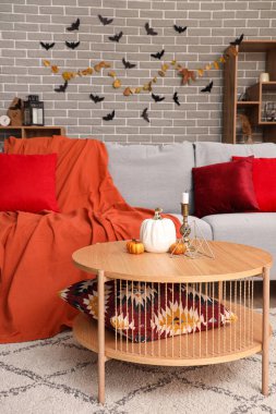 Oturma odasının içi Cadılar Bayramı için kanepe ve masa ile dekore edilmiş.