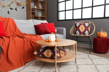 Oturma odasının içi Cadılar Bayramı için kanepe ve masa ile dekore edilmiş.