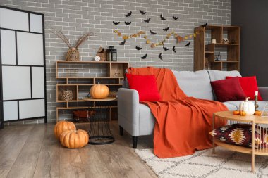 Cadılar Bayramı için kanepe ve balkabaklarıyla dekore edilmiş oturma odasının içi.