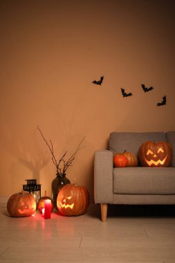 İçinde kanepe ve Cadılar Bayramı balkabağı olan karanlık bir oturma odası.