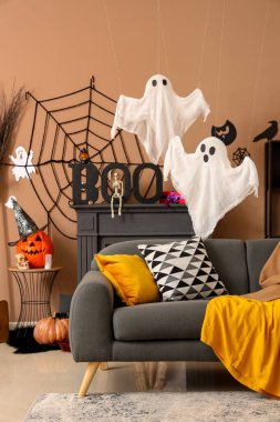 Gri kanepeli, hayaletli ve cadılar bayramı dekorasyonlu festival salonu.