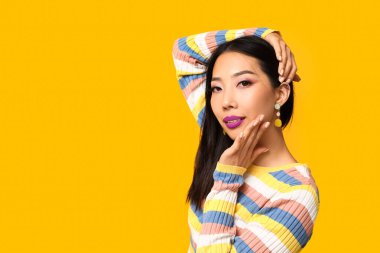 Sarı arka planda mor ruj sürmüş güzel bir Asyalı kadın.