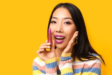 Sarı arka planda ruj izi olan güzel Asyalı kadın.