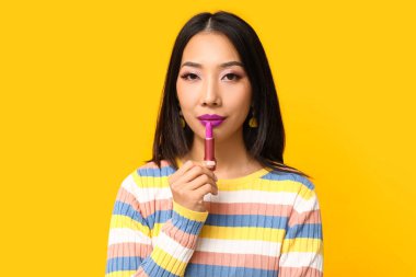 Sarı arka planda ruj izi olan güzel Asyalı kadın.