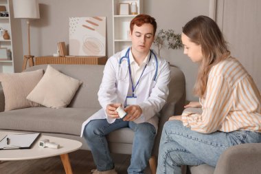 Erkek doktor, evdeki genç bayana ilaç yazıyor.