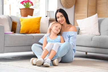 Küçük kızı evde sarılırken mutlu bir anne.