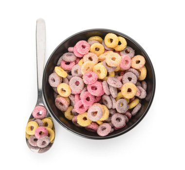 Siyah kâse ve kaşık, beyaz arka planda renkli tatlı mısır gevreği halkaları.