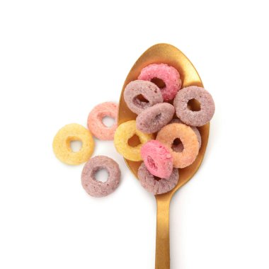 Beyaz arka planda renkli tatlı mısır gevreği halkaları olan kaşık