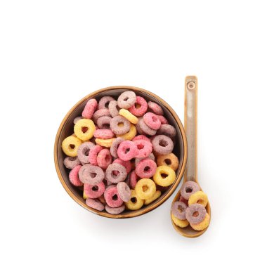 Beyaz arka planda renkli mısır gevreği halkaları olan kase ve kaşık.