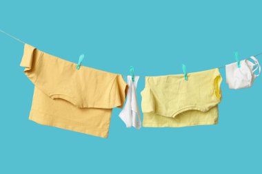 Mavi arka planda ipte asılı elbiseler