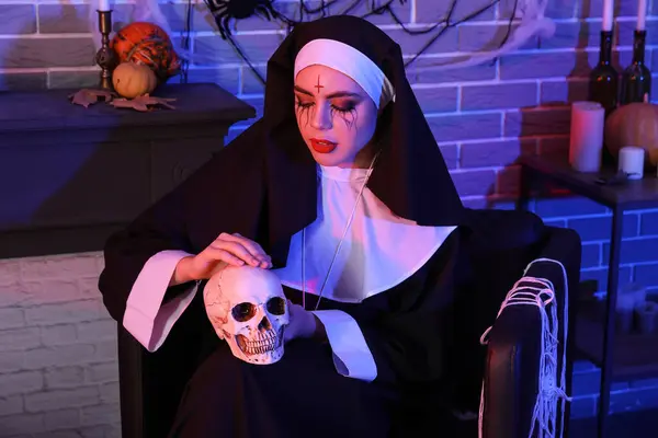 stock image Young woman dressed as nun with skull at Halloween party