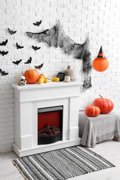 Cadılar Bayramı için dekore edilmiş oturma odasının içi şömine, balkabağı ve kağıt yarasalarla süslenmiş.