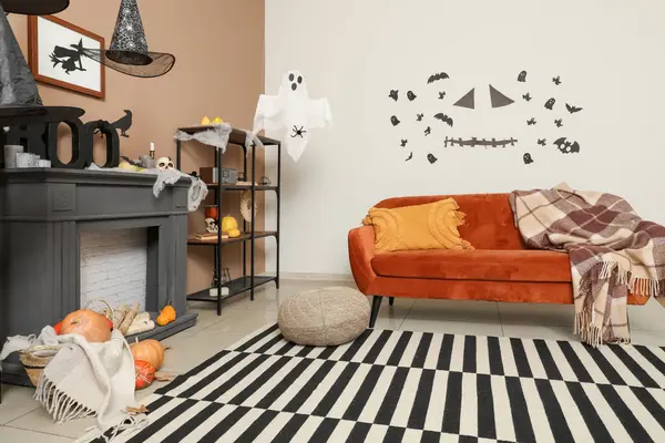 Cadılar Bayramı için kanepe ve şömine rafıyla dekore edilmiş oturma odasının içi.