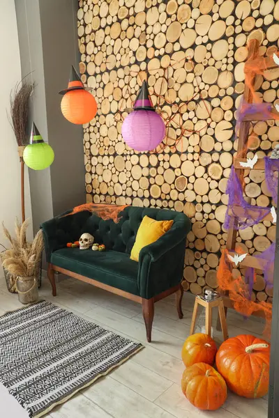 Cadılar Bayramı için yeşil kanepe ve merdivenle dekore edilmiş oturma odasının içi.
