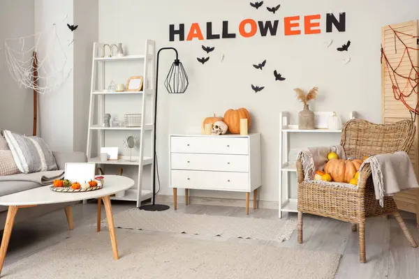 Cadılar Bayramı için dekore edilmiş aydınlık oturma odasının içinde çekmeceler ve raf üniteleri var.