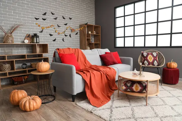 Oturma odasının içi Cadılar Bayramı için kanepe ve masa ile dekore edilmiş.