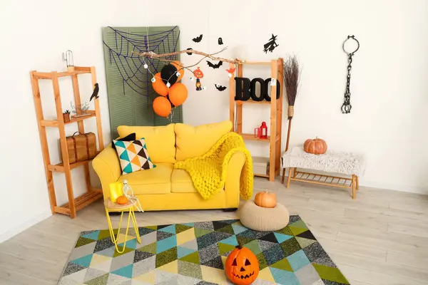 Cadılar Bayramı için dekore edilmiş oturma odasının içi kanepe ve raf üniteleriyle dolu.