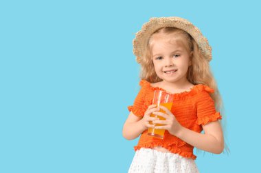 Mavi arka planda bir bardak portakal suyu olan sevimli küçük kız.